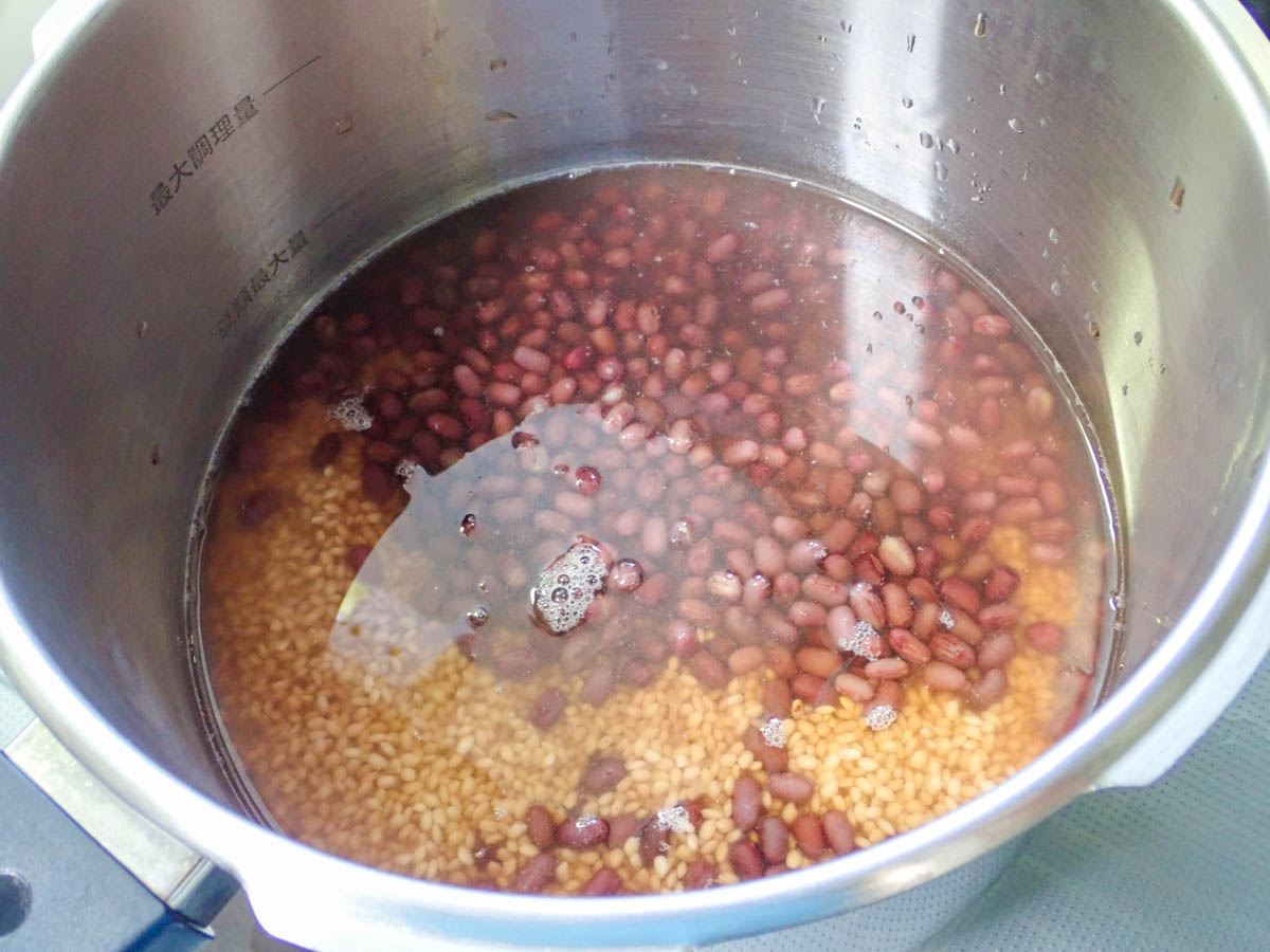 圧力鍋にもち米と小豆、ゆで汁を入れる